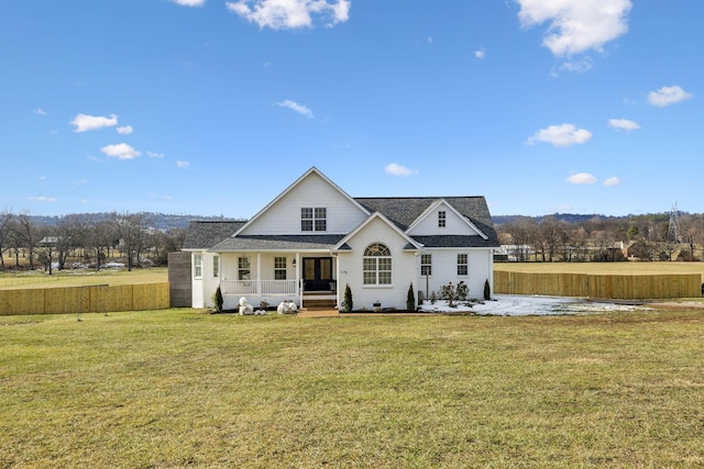 rear view of house with covered porch and a yard