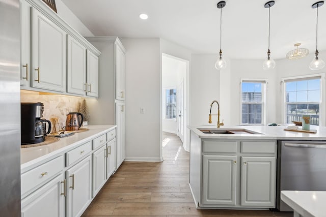 kitchen featuring appliances with stainless steel finishes, tasteful backsplash, hanging light fixtures, and sink