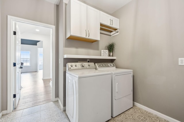 clothes washing area with cabinets, independent washer and dryer, and light tile patterned flooring