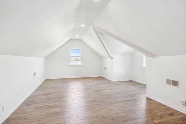 bonus room with lofted ceiling and light hardwood / wood-style floors