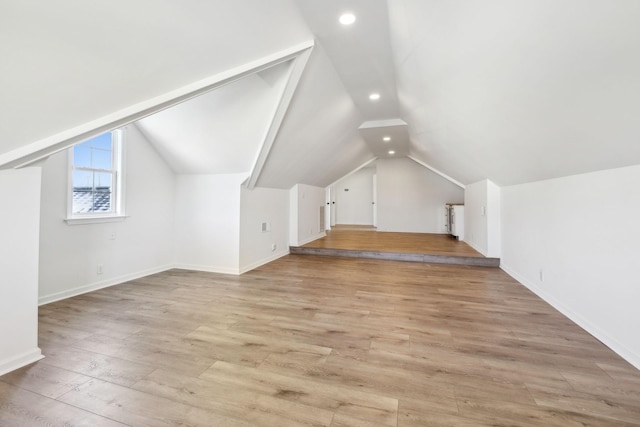 bonus room with lofted ceiling and light wood-type flooring