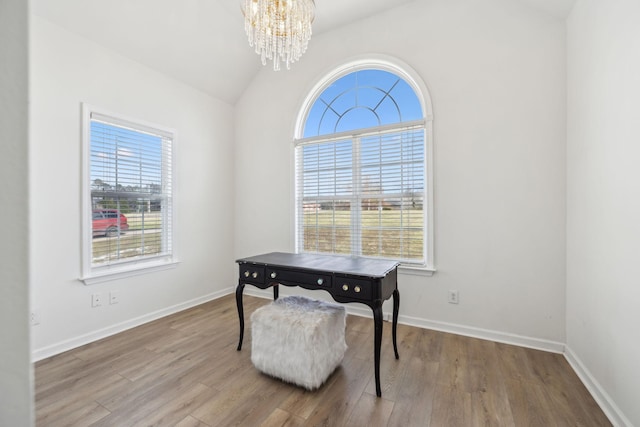 home office with vaulted ceiling, an inviting chandelier, plenty of natural light, and hardwood / wood-style flooring