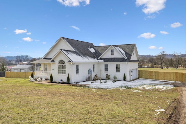 rear view of property featuring a porch, a yard, and a garage