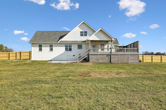 rear view of property featuring ceiling fan, a deck, and a yard