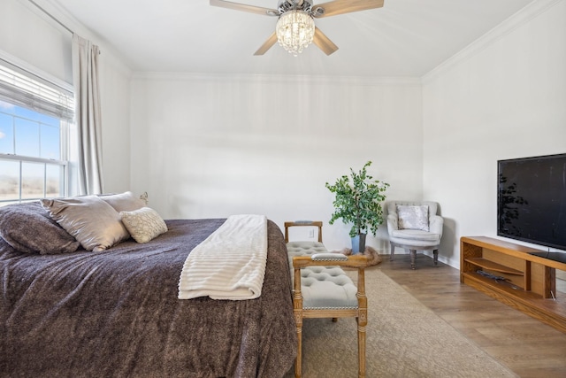 bedroom featuring ceiling fan, light hardwood / wood-style floors, and crown molding