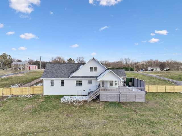 rear view of property featuring a deck and a yard