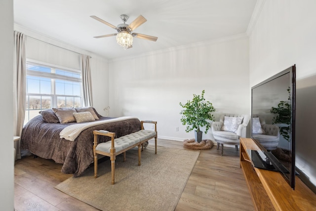 bedroom featuring ceiling fan, ornamental molding, and light hardwood / wood-style floors