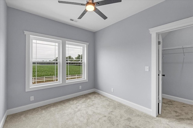 unfurnished bedroom with a closet, ceiling fan, and light colored carpet