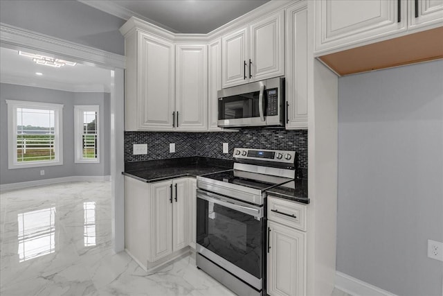 kitchen featuring dark stone counters, decorative backsplash, ornamental molding, white cabinetry, and stainless steel appliances