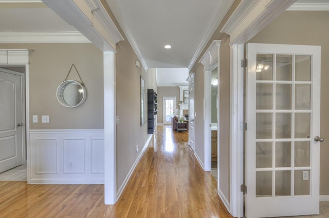 hallway with crown molding and light wood-type flooring