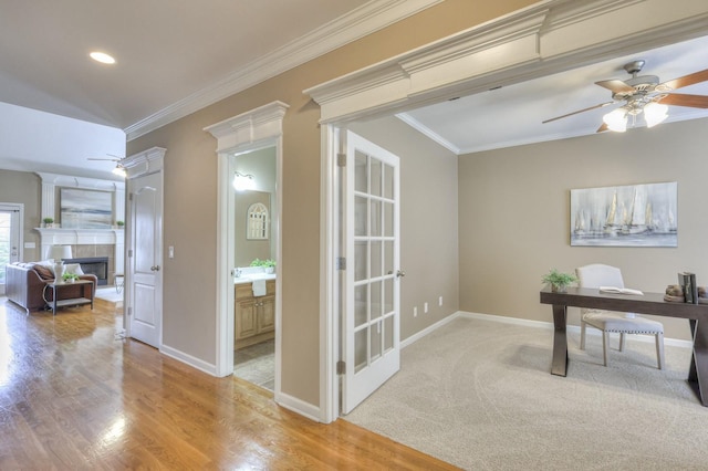 office area with a tiled fireplace, ceiling fan, light hardwood / wood-style floors, and ornamental molding