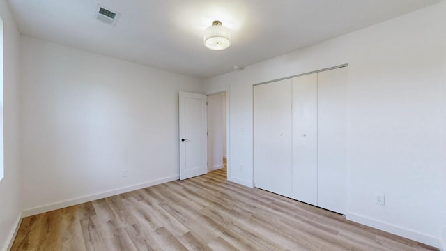 unfurnished bedroom featuring a closet and light hardwood / wood-style floors