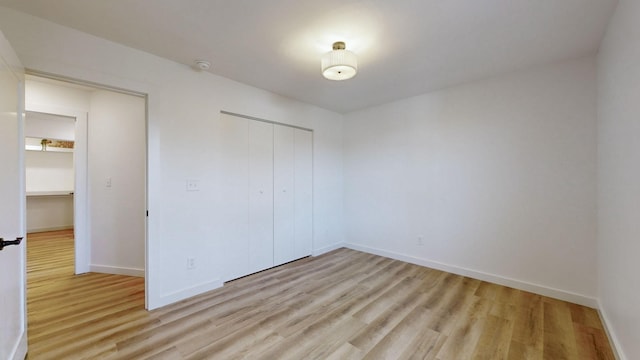 unfurnished bedroom with light hardwood / wood-style floors and a closet