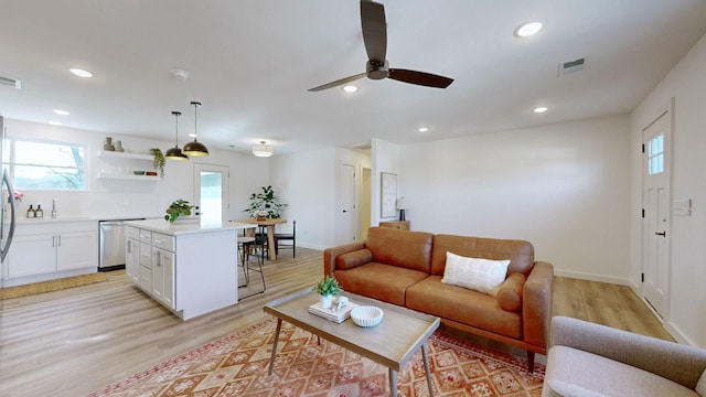 living room with light wood-type flooring and ceiling fan