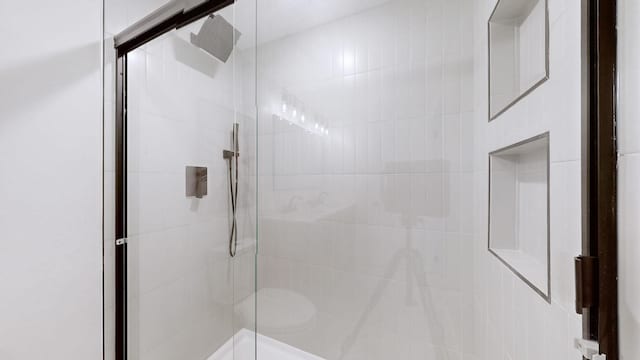 bathroom with a shower with door