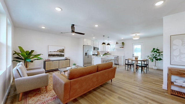 living room with ceiling fan and light hardwood / wood-style flooring