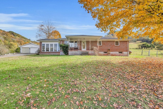 single story home featuring a front lawn, covered porch, an outdoor structure, and a garage