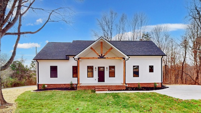 modern farmhouse with covered porch and a front lawn