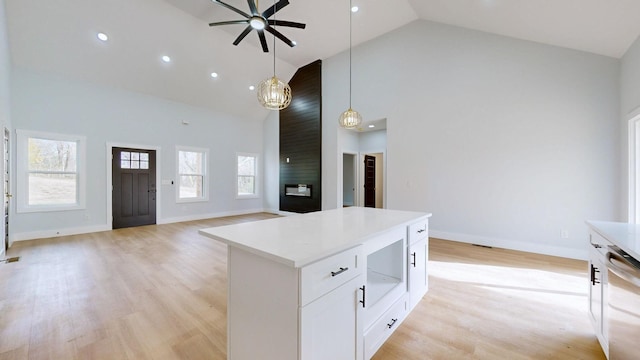 kitchen with dishwasher, hanging light fixtures, high vaulted ceiling, light hardwood / wood-style floors, and white cabinets