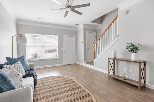 living room with hardwood / wood-style flooring, ceiling fan, and crown molding