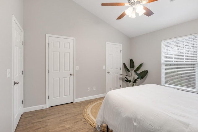 bedroom with light hardwood / wood-style floors, vaulted ceiling, and ceiling fan