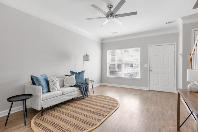 living area featuring ceiling fan, light hardwood / wood-style floors, and ornamental molding