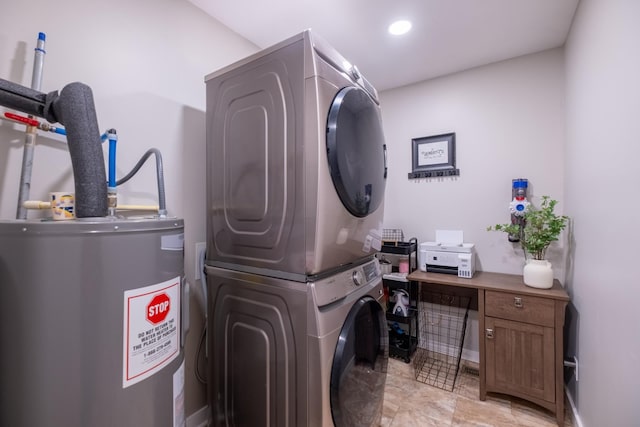 washroom with stacked washer / drying machine and water heater