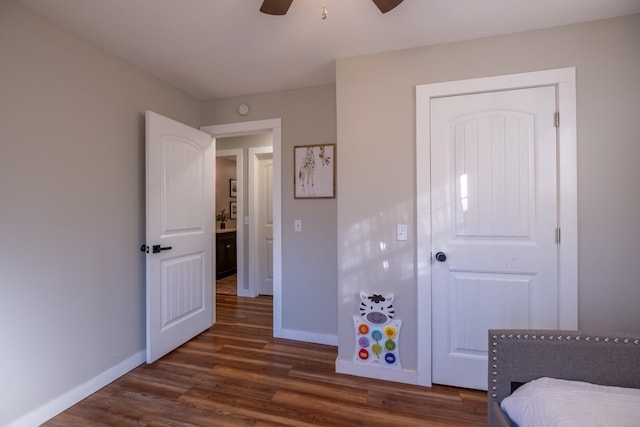 bedroom featuring dark hardwood / wood-style flooring, ceiling fan, and a closet