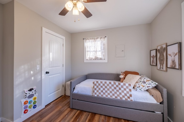 bedroom featuring electric panel, a closet, dark wood-type flooring, and ceiling fan