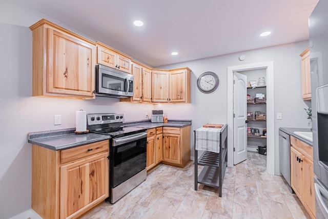 kitchen featuring light brown cabinetry and appliances with stainless steel finishes