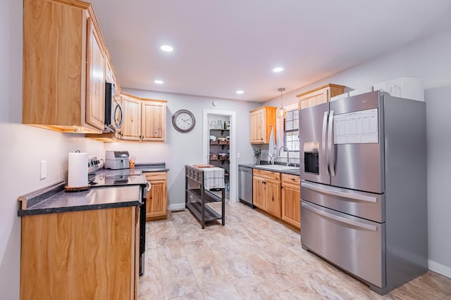 kitchen with light brown cabinetry, stainless steel appliances, hanging light fixtures, and sink