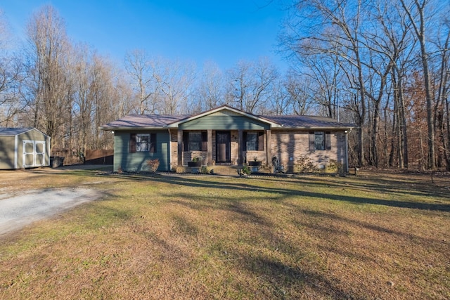 ranch-style home with a storage unit, a porch, and a front lawn