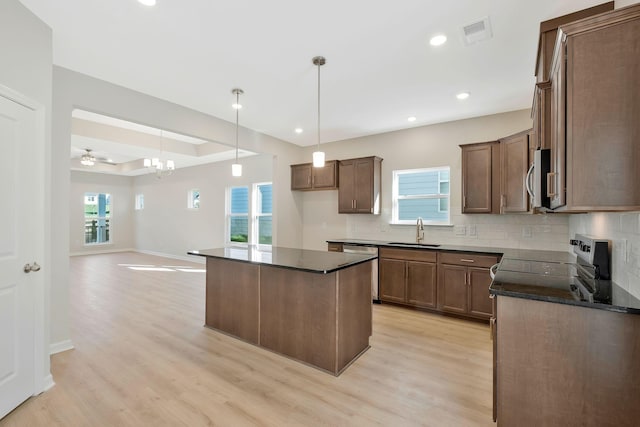 kitchen with ceiling fan, sink, stainless steel appliances, light hardwood / wood-style flooring, and a kitchen island