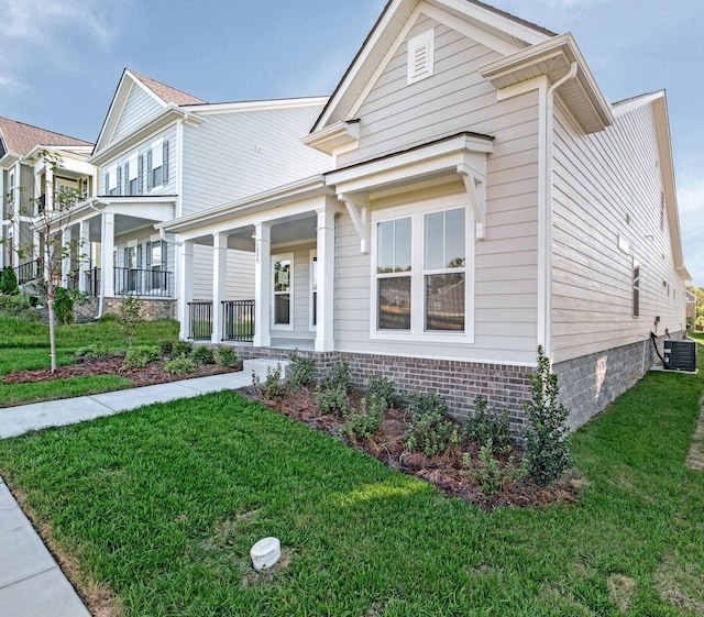 view of front facade with central AC, a porch, and a front yard