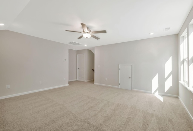 carpeted spare room featuring ceiling fan, a healthy amount of sunlight, and lofted ceiling