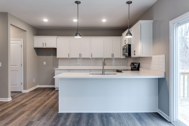 kitchen with appliances with stainless steel finishes, white cabinetry, and pendant lighting