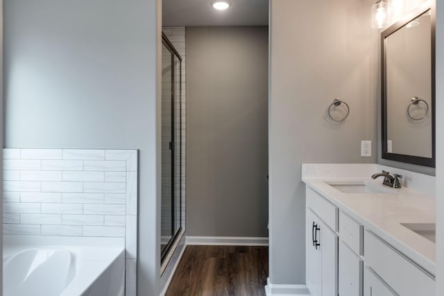 bathroom with hardwood / wood-style floors, vanity, and independent shower and bath