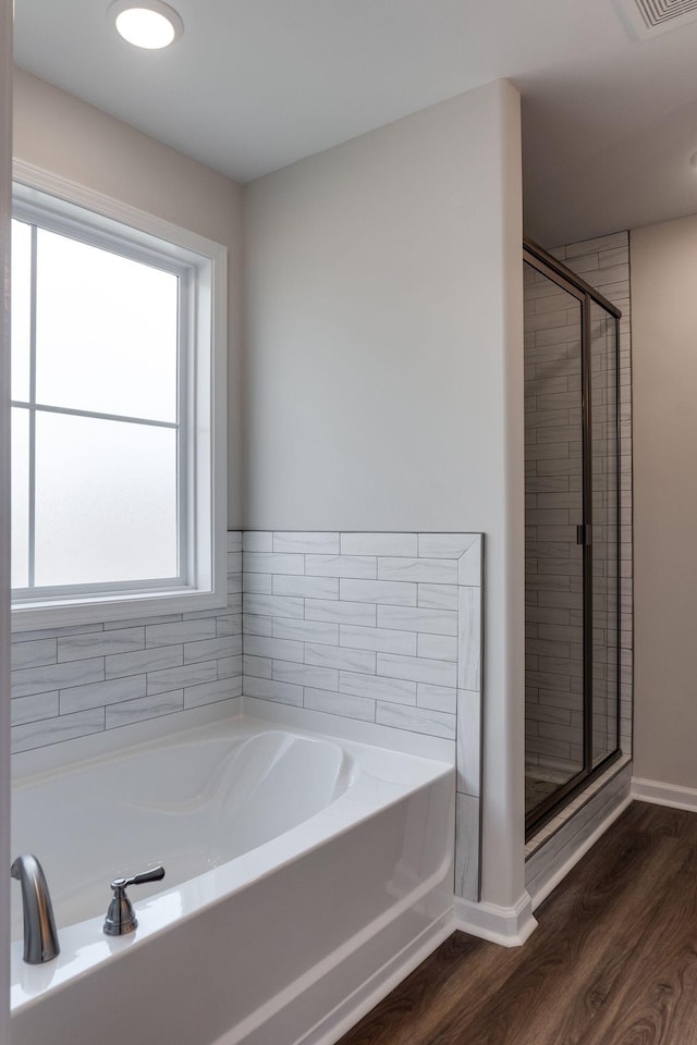 bathroom with hardwood / wood-style flooring and plus walk in shower