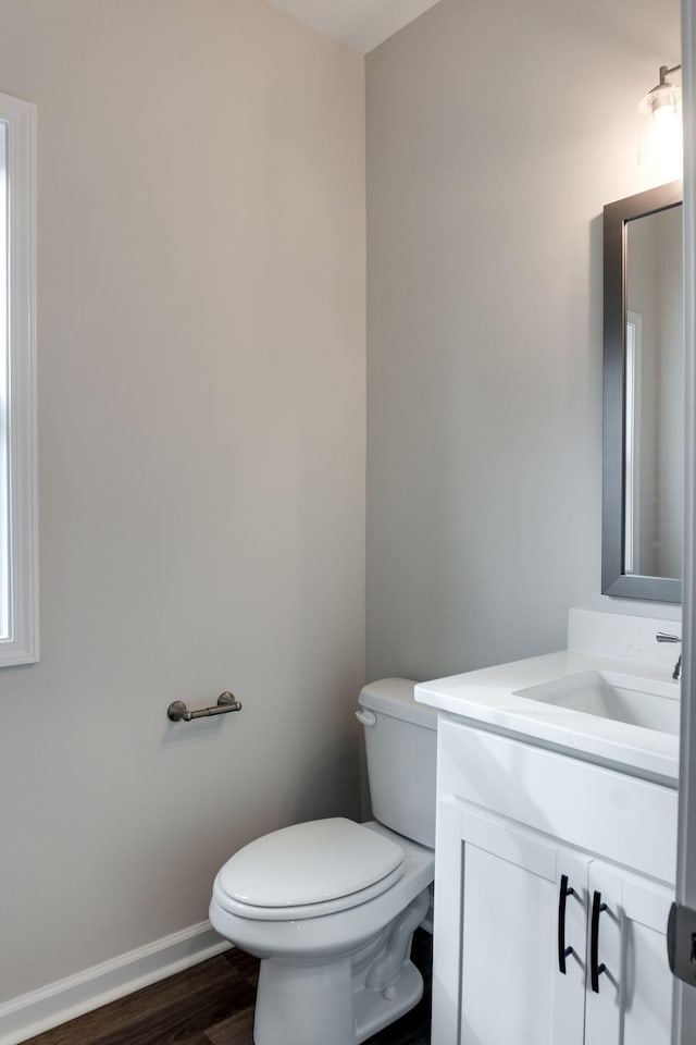 bathroom with hardwood / wood-style floors, vanity, and toilet