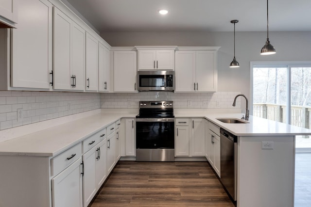 kitchen featuring white cabinetry, kitchen peninsula, sink, and appliances with stainless steel finishes