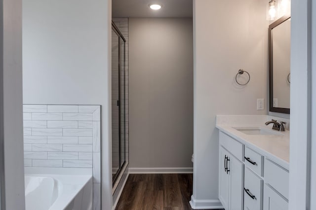 bathroom with plus walk in shower, vanity, and hardwood / wood-style flooring