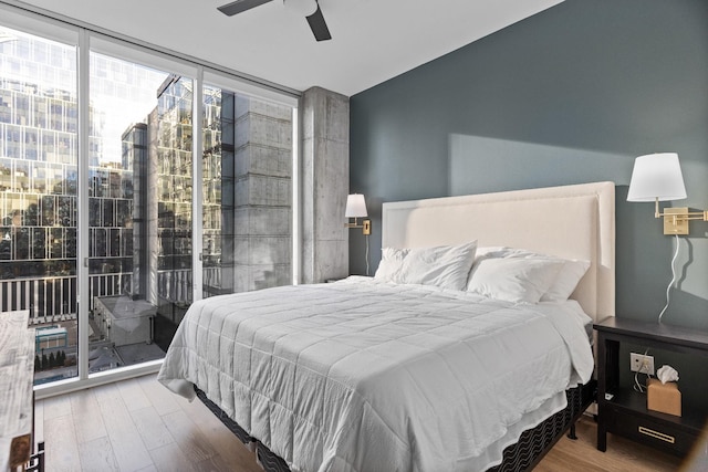 bedroom featuring floor to ceiling windows, access to outside, hardwood / wood-style flooring, and ceiling fan