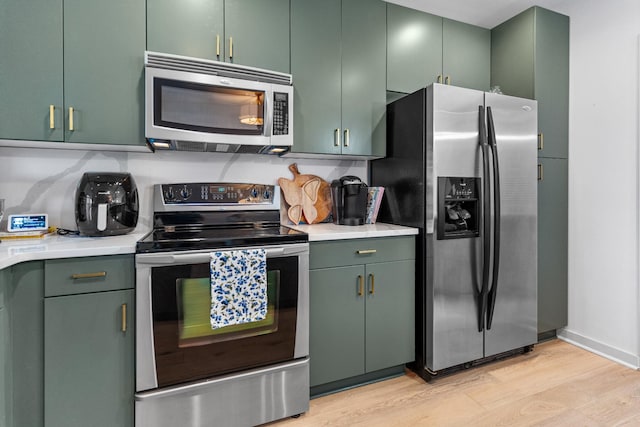 kitchen featuring green cabinets, light hardwood / wood-style floors, and stainless steel appliances