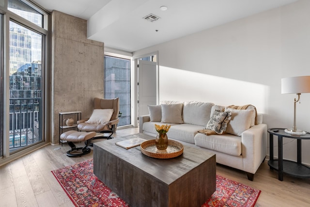 living room with expansive windows and light wood-type flooring