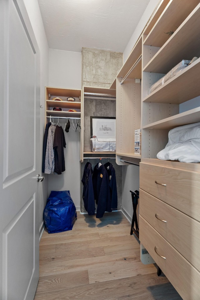 walk in closet with light wood-type flooring