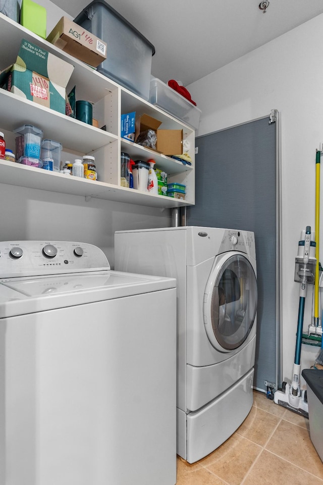 washroom featuring independent washer and dryer and light tile patterned floors