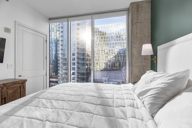 bedroom featuring access to outside and a wall of windows