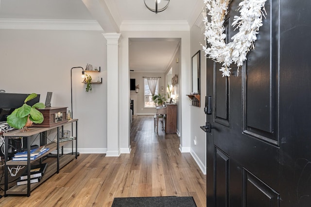 foyer entrance with hardwood / wood-style flooring, crown molding, and decorative columns