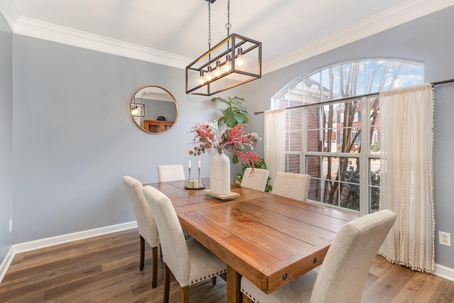 dining area with dark hardwood / wood-style flooring and crown molding