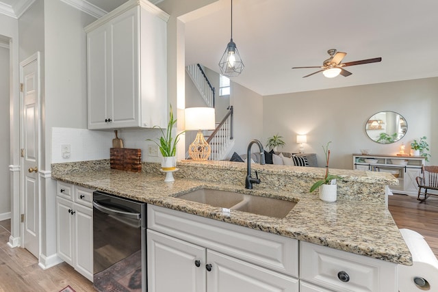 kitchen featuring sink, white cabinetry, black dishwasher, light stone countertops, and light wood-type flooring